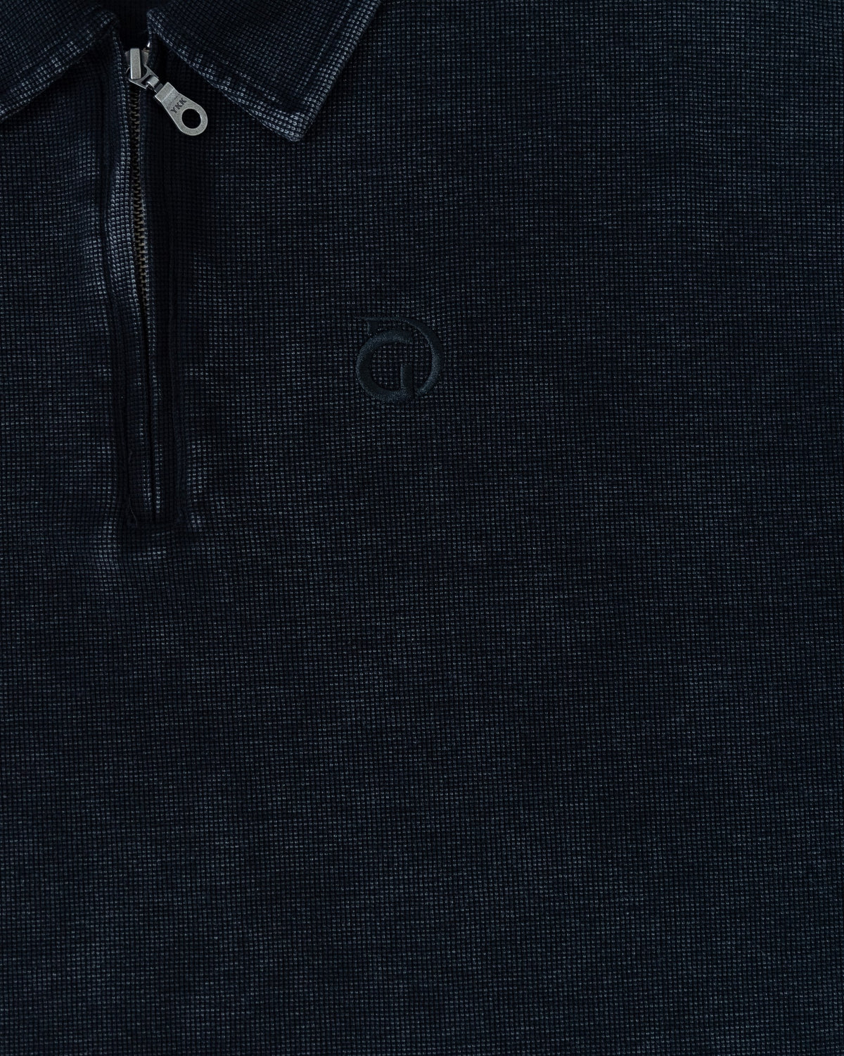 The Standard Zip Polo in Black, detail of the zip placket and waffle fabric