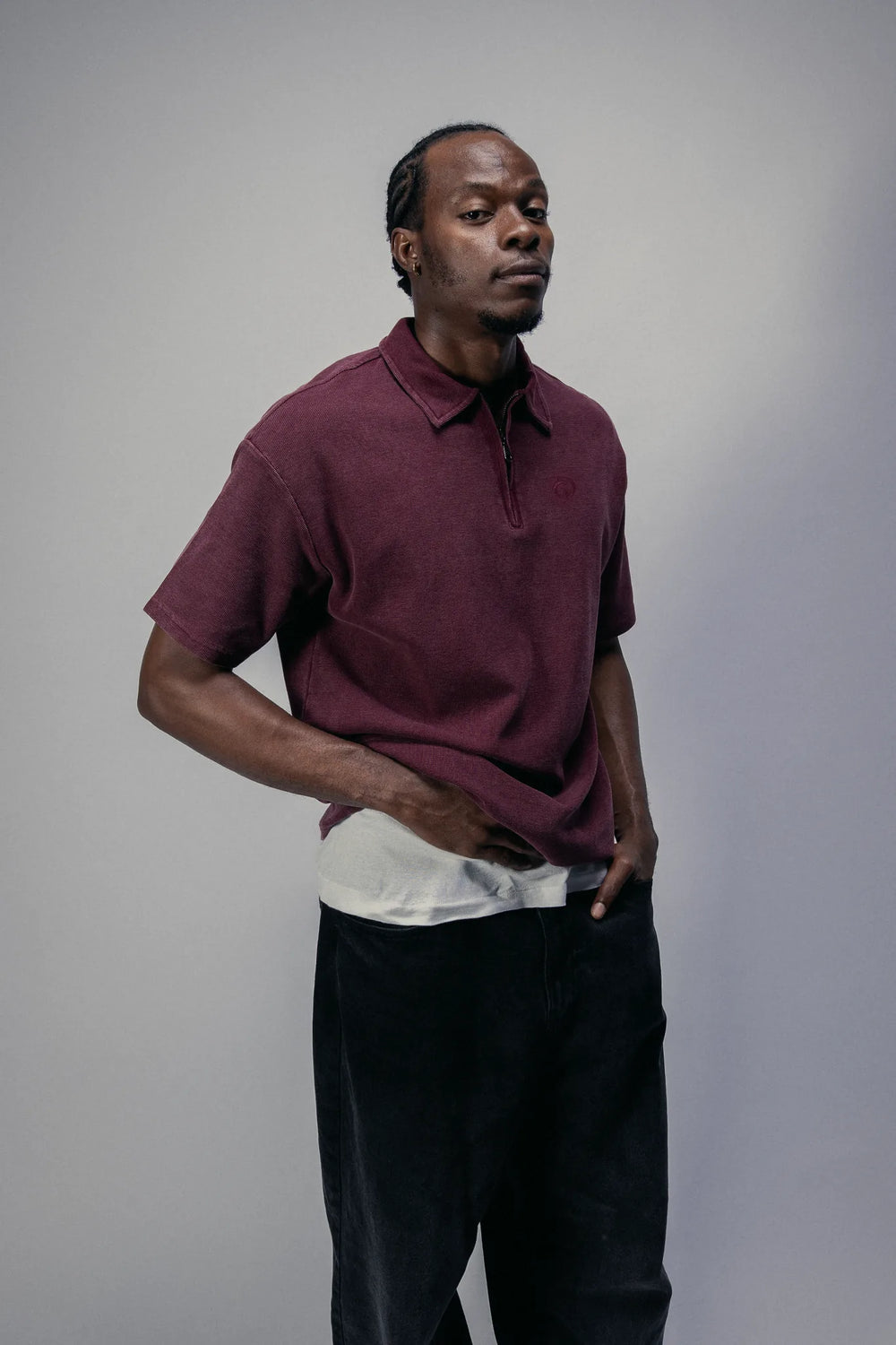 Short-sleeve zip polo in Oxblood, worn with black trousers