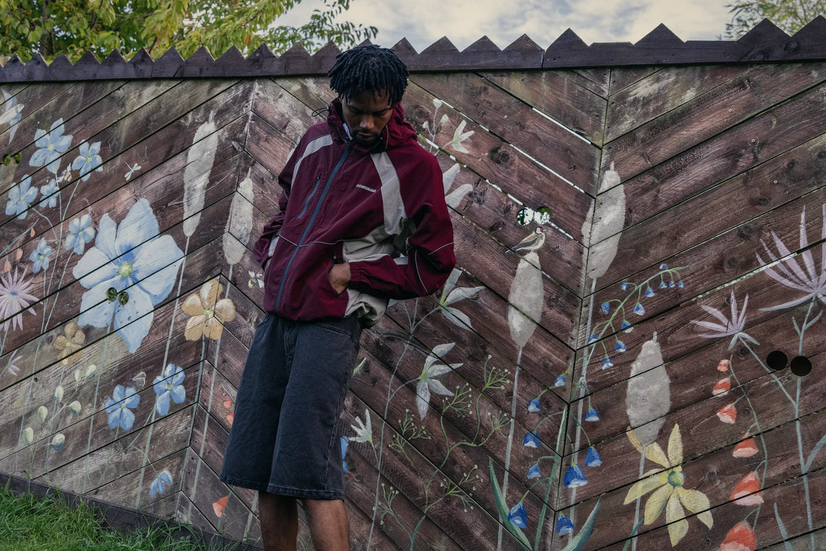 Contour Tech Jacket in Oxblood against a painted wall